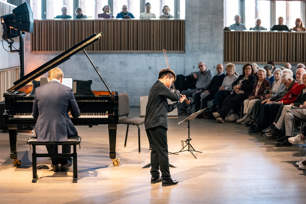 Student performing to a full concert hall audience